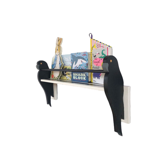 Wall-mounted bookshelf with parrot brackets and books on a white wall